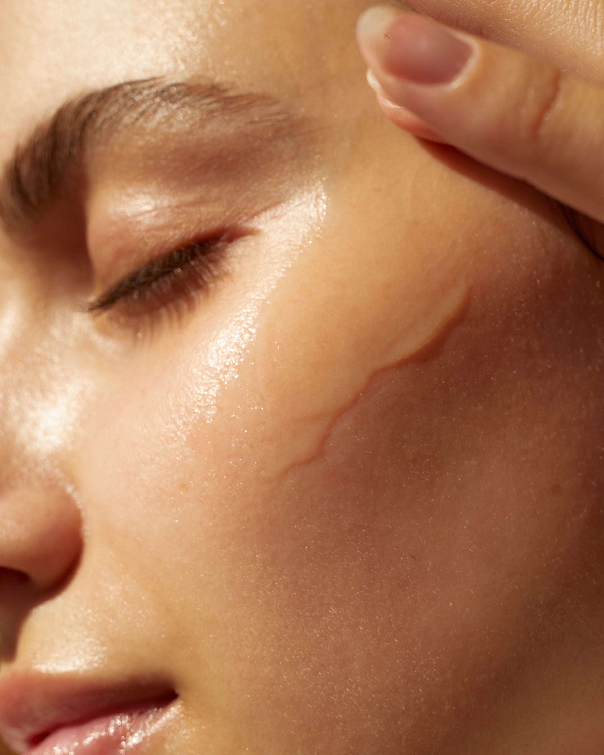 The Collagen Serum from SolRay Beauty being applied to a woman's face, highlighting its use in a daily skincare routine.